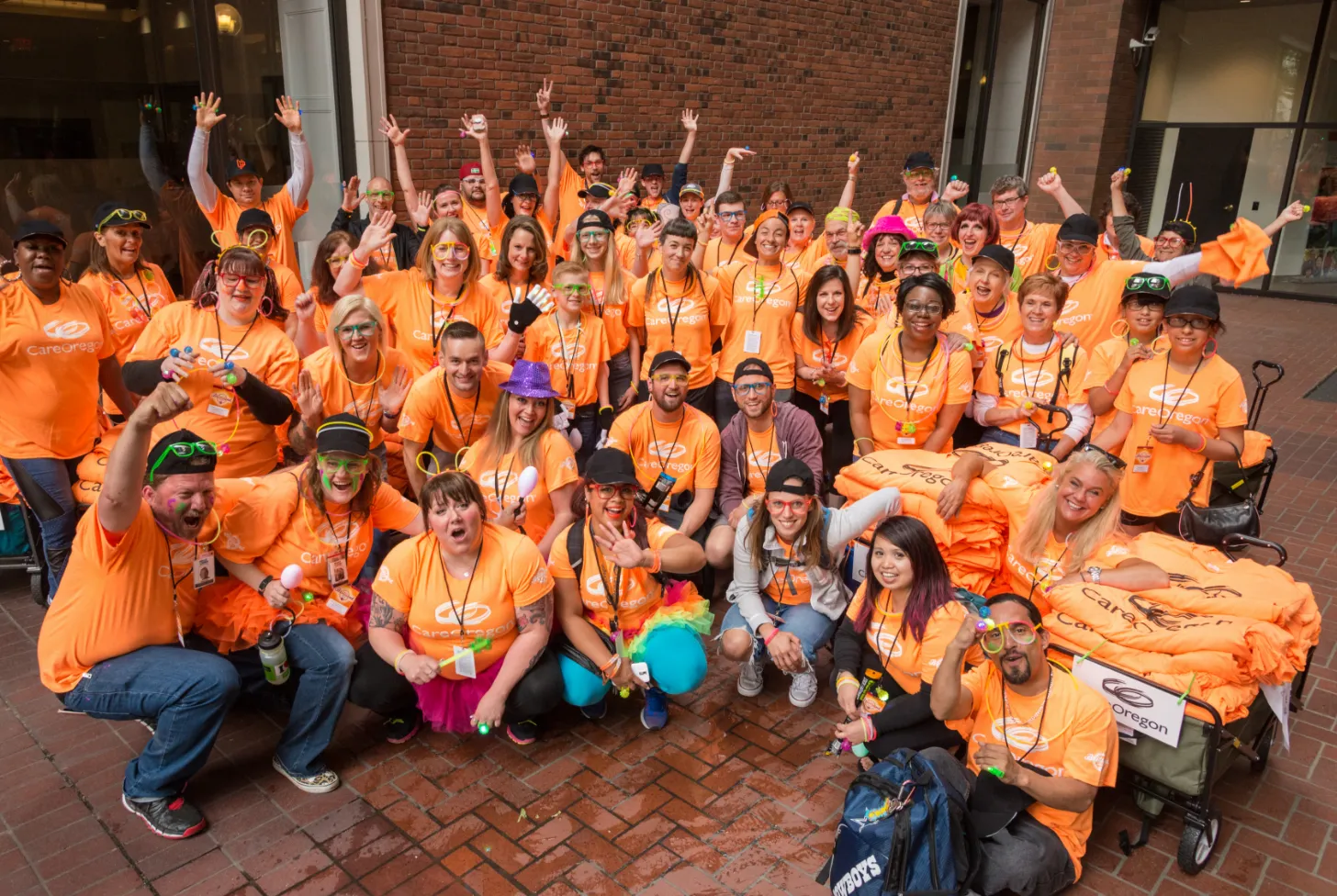 un grupo de empleados sonrientes de CareOregon con camisetas naranjas