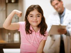 Girl at doctor's office flexing arm after receiving her shot.