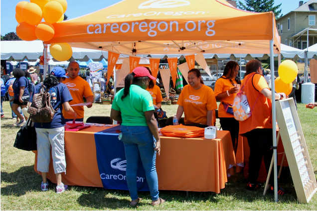 People working at a Connect to Care event at an orange tent.